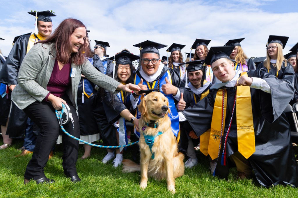 Graduating students pose with Roger the dog